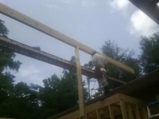 Carpenter setting a ridge beam over a new addition frame — Ice Dam Removal by Roofing Brothers in South Greenfield