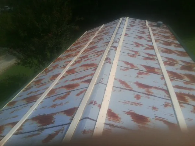 Rusted metal roof panels with new wood purlins before replacement — Storm Damage Roof Repair in South Greenfield by Roofing Brothers