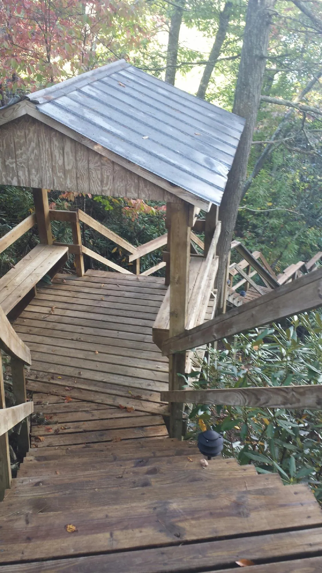 Metal roofed shelter over wooden steps on a wooded walkway — Skylight Repair & Installation work by our crew in South Greenfield