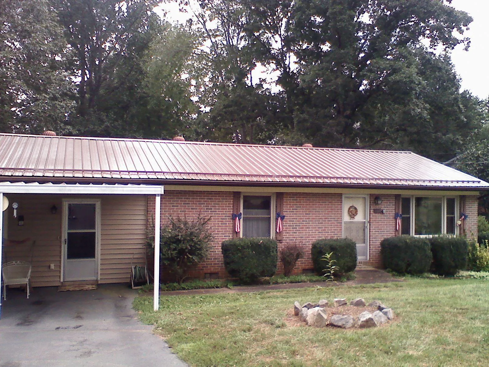 Bronze metal roof and carport on a brick ranch home — Roof Repair work by our crew in South Greenfield